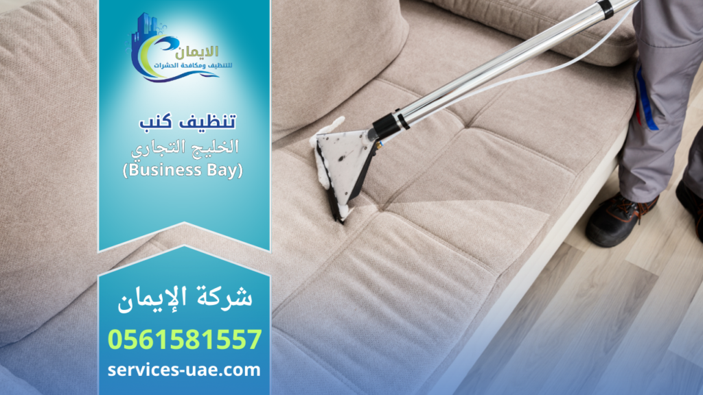 عامل يستخدم جهاز شفط بفوهة مثلثة لتنظيف كنب قماشي ضمن خدمة شركة تنظيف كنب في الخليج التجاري (Business Bay) داخل المنزل.