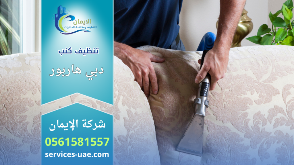 عامل يستخدم جهاز شفط لتنظيف ظهر كنب قماشي ضمن خدمة شركة تنظيف كنب في دبي هاربور داخل المنزل.