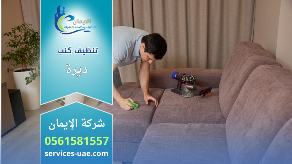 عامل نظافة يقوم بتنظيف كنب قماشي بدقة باستخدام أدوات يدوية وجهاز شفط ضمن خدمات شركة تنظيف كنب في ديرة.