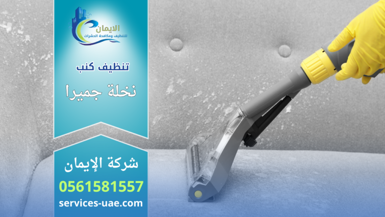 عامل يستخدم جهاز شفط لتنظيف كنب قماشي ضمن خدمة شركة تنظيف كنب في نخلة جميرا داخل غرفة المعيشة.